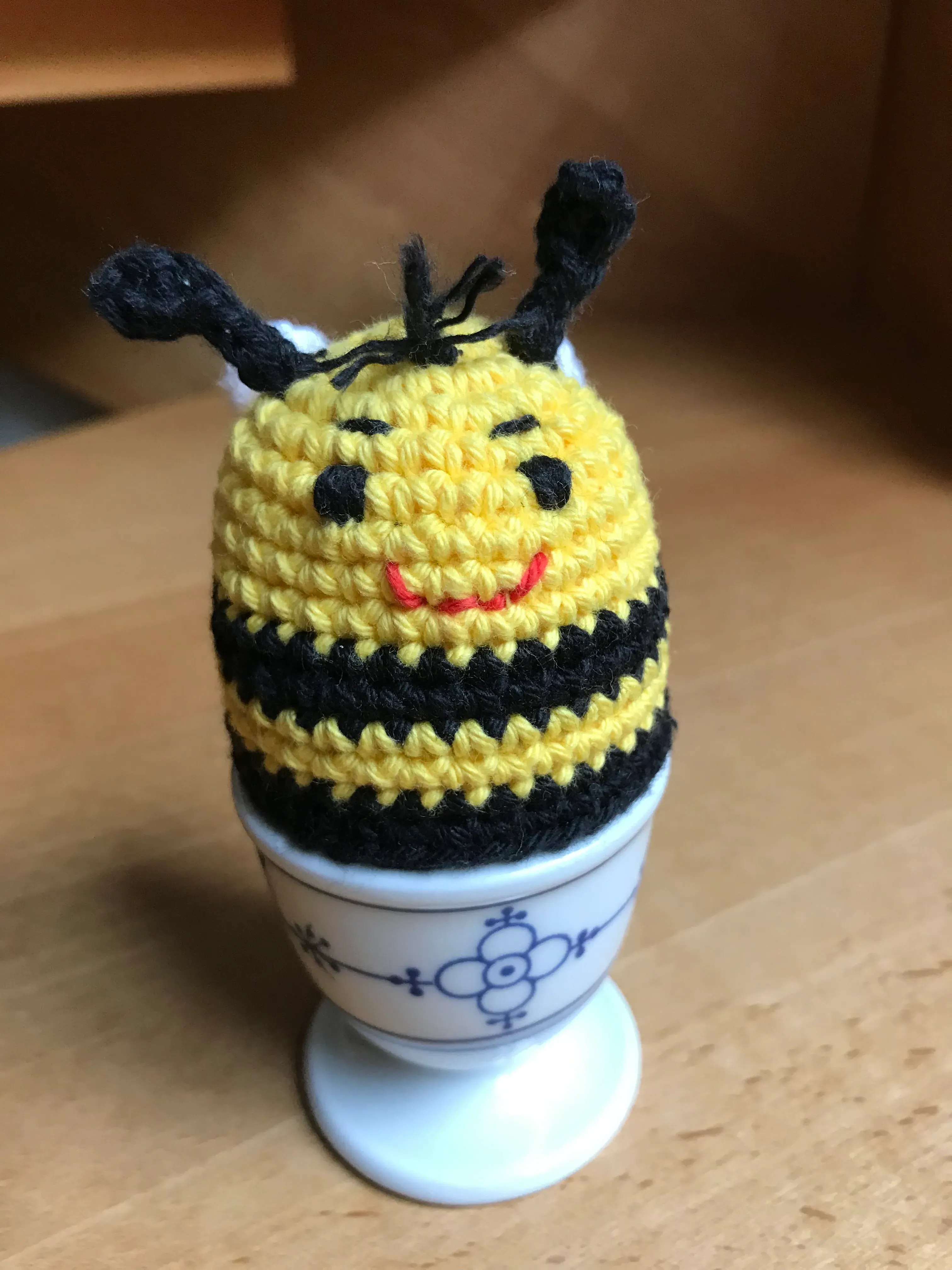 Eierwärmer Biene mit angenähten Flügeln und Pailettenaugen